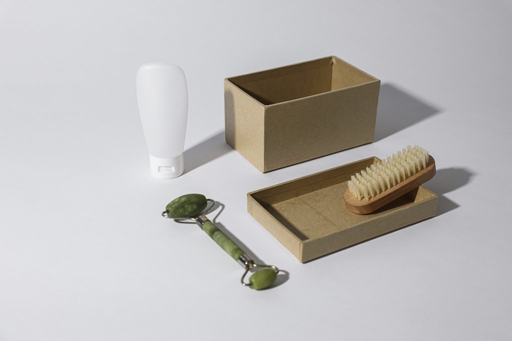 Cup of Couple - A beautiful minimalist arrangement of a jade roller, brush, and cosmetic tube on a white background.