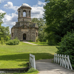 Nico Becker - Stone ruins of the Merkur Temple surrounded by lush greenery in Schwetzingen Park.