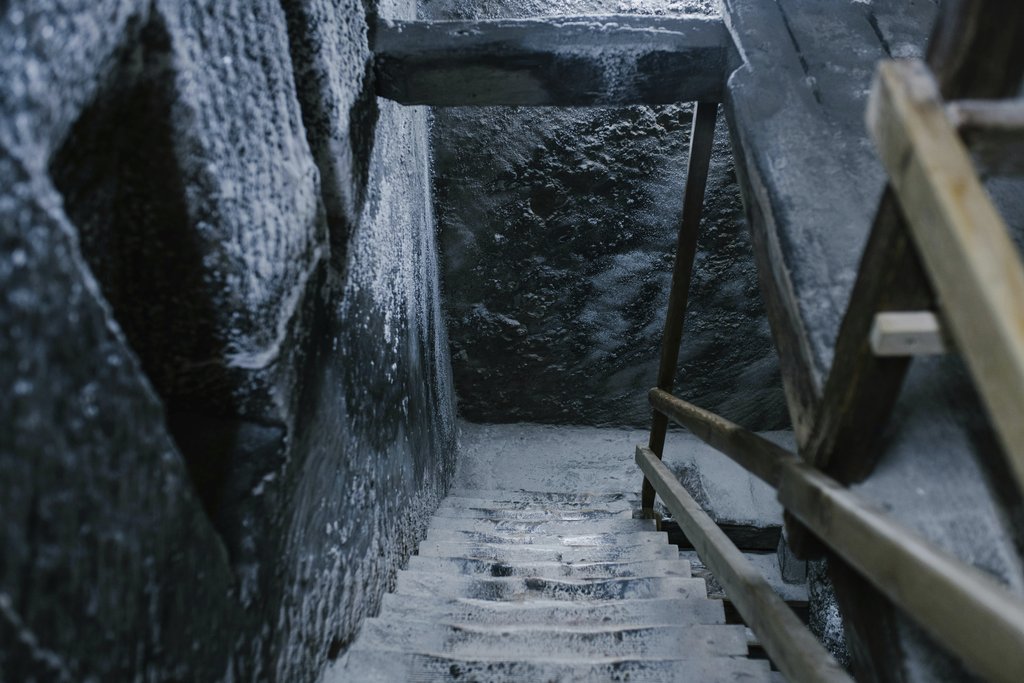 Julia Volk - From above of aged stone stairway covered with salt in ancient cave with shabby walls and wooden railings in Registry Chamber of Salina Turda mine