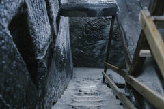 Julia Volk - From above of aged stone stairway covered with salt in ancient cave with shabby walls and wooden railings in Registry Chamber of Salina Turda mine