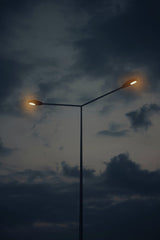 Atahan Demir - Streetlamp illuminates evening sky with dramatic clouds creating a moody atmosphere.