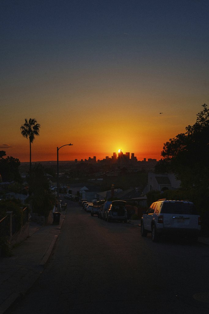 Lukas Rodriguez - Experience the stunning view of a sunset casting golden hues over the Los Angeles skyline.
