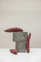 Cup of Couple - A creative still life featuring sweet potatoes artfully arranged on gray concrete blocks, showcasing texture contrast.