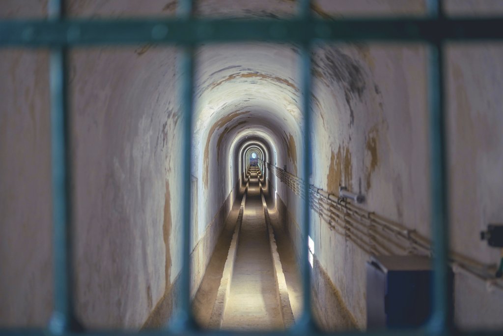 Nuno Magalhães - Long passage tunnel with diminishing perspective and atmospheric lighting creating a sense of mystery.