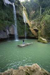 Nguyen Khuong - A person on a raft embraces nature under a waterfall in Sơn La, Vietnam.