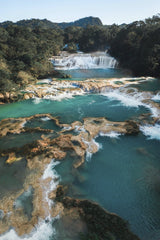 Mikhail Nilov - A breathtaking aerial view of stunning turquoise waterfalls amidst lush greenery.