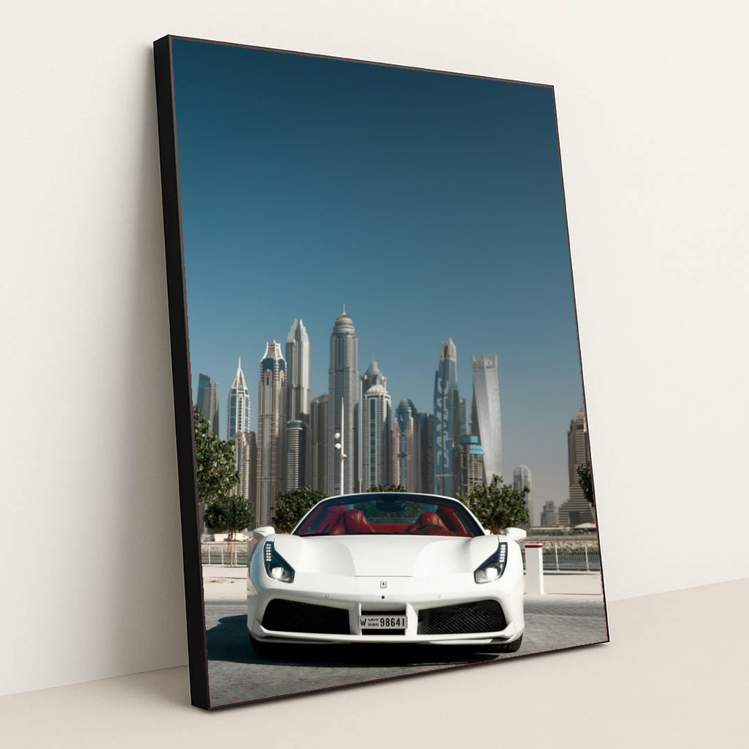 This photo shows a white Ferrari convertible with red seats parked in front of Dubai skyscrapers under a clear blue sky, in a black frame.