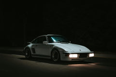 Porsche 911 Late Night Drives with sleek white exterior gliding on empty road under night sky, perfect car wall art.