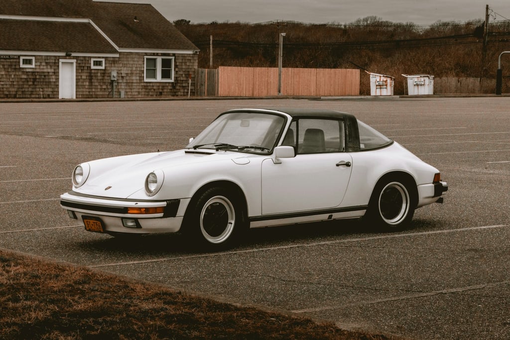 Vintage Porsche 911 SC Targa parked in a calm lot, showcasing its elegant design for stunning car wall art.
