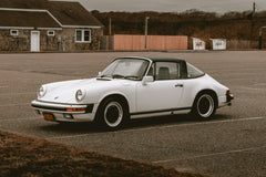 Vintage Porsche 911 SC Targa parked in a calm lot, showcasing its elegant design for stunning car wall art.
