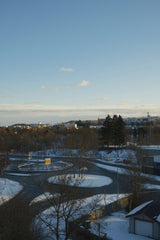 Dua'a Al-Amad - Beautiful winter cityscape featuring a snowy road and distant buildings under a clear sky.