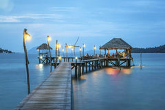 Pixabay - Illuminated pier and bungalow on a tranquil tropical sea at twilight.