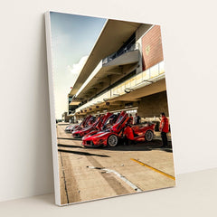 Ferrari FXX-Ks at the Track, showcasing a row of gleaming red supercars under sunny skies with doors raised.