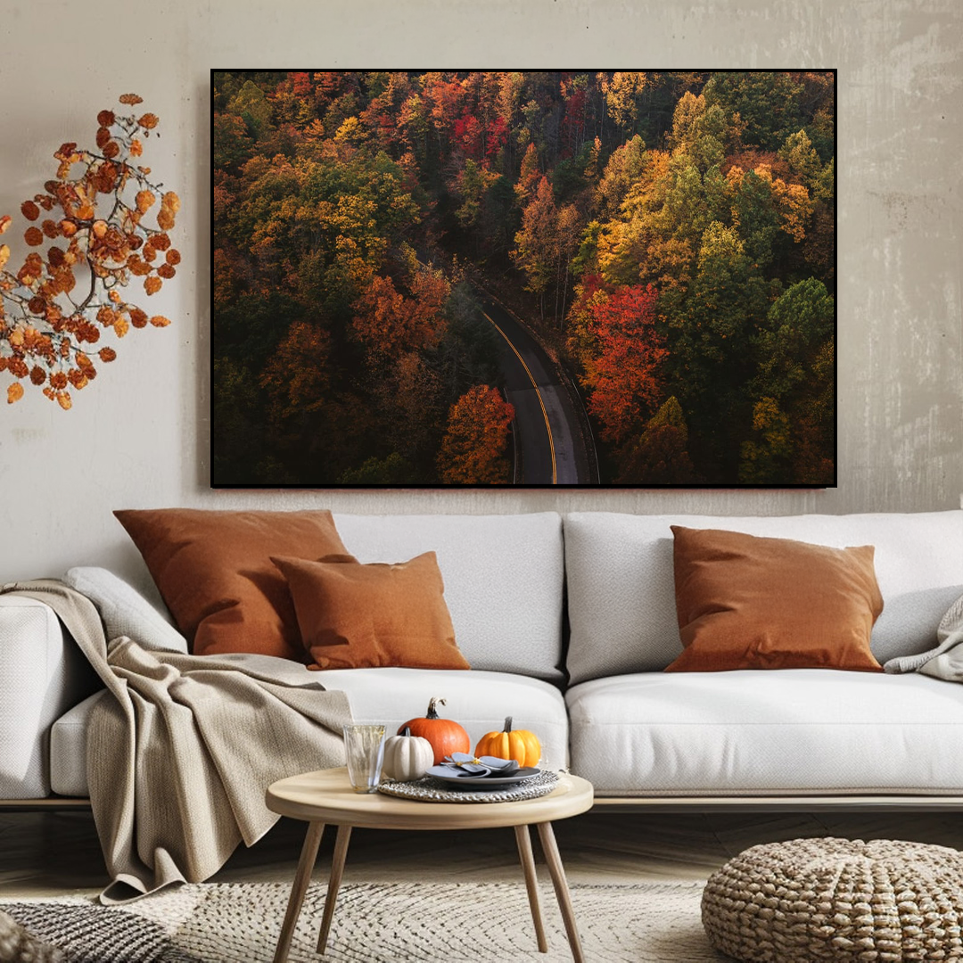 Living room with a white sofa, autumn-themed wall art, and decorative elements.