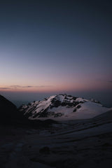 Slava Auchynnikau - A snow covered mountain with a sky background