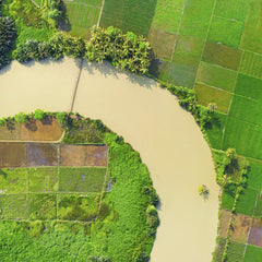 Tom Fisk - Aerial image showcasing lush green farmland and a winding river, highlighting rural agriculture.