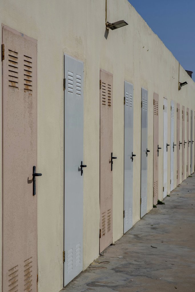Victor  Moragriega - Row Of Colorful Beach Changing Room Doors