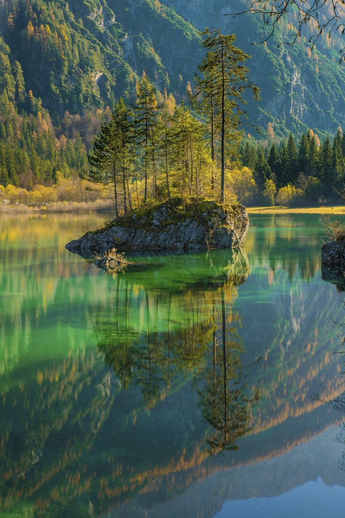 Pixabay - Stunning fall scenery of a tranquil mountain lake reflecting surrounding trees and mountains.