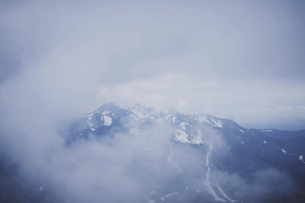 Tommes Frites - Scenic view of snow-covered mountains shrouded in mist in Lenggries, Bavaria.