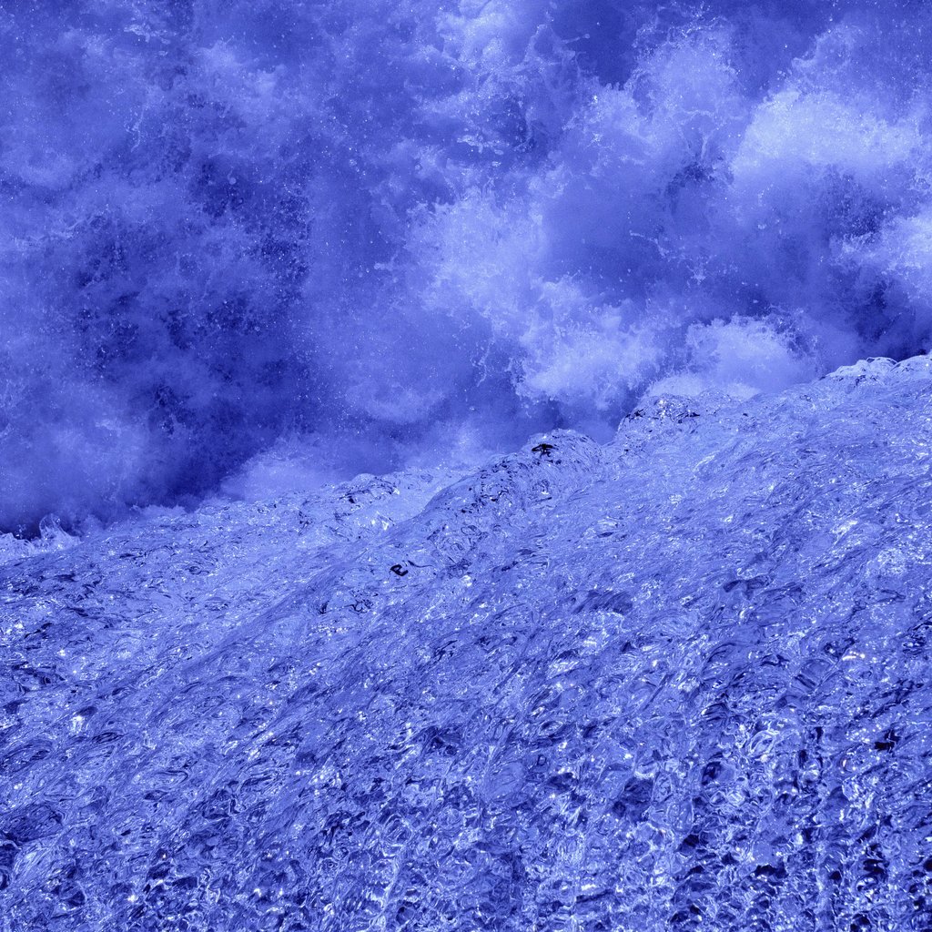 Damir Mijailovic - Close-up of a frozen waterfall's vibrant blue ice and cascading texture, capturing a winter wonderland.