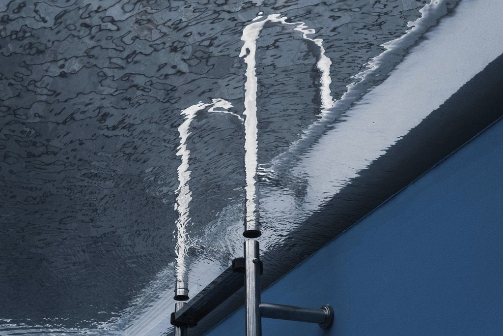 David Yu - Creative water reflection with metal pipe in a swimming pool.