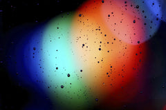 deep Bhullar - Vivid abstract image with rainbow colors and water droplets on glass.