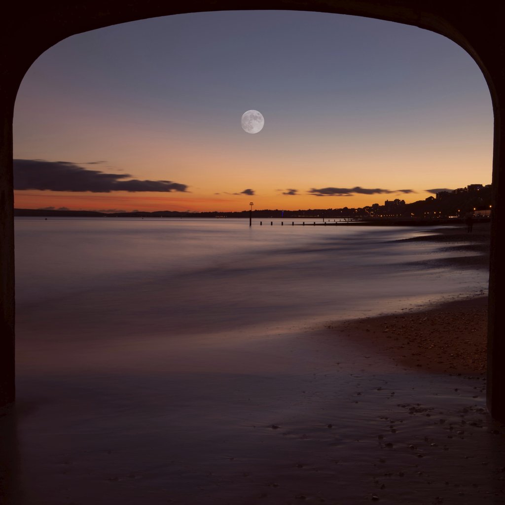 Mohammad Abbasi - Serene sunset view at Bournemouth beach framed by a pier with a moonlit sky.