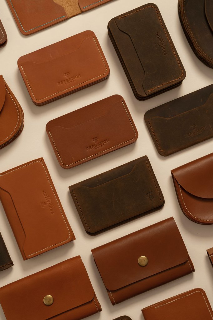 Gül Işık - Elegant assortment of handcrafted brown leather wallets in a flat lay display.