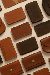 Gül Işık - Elegant assortment of handcrafted brown leather wallets in a flat lay display.