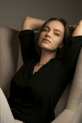 Miguel Cuenca - Casual portrait of a young woman with a relaxed pose, arms above head.