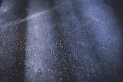 Tim Mossholder - Close-up of shimmering bokeh lights on a textured dark surface creating an abstract pattern.