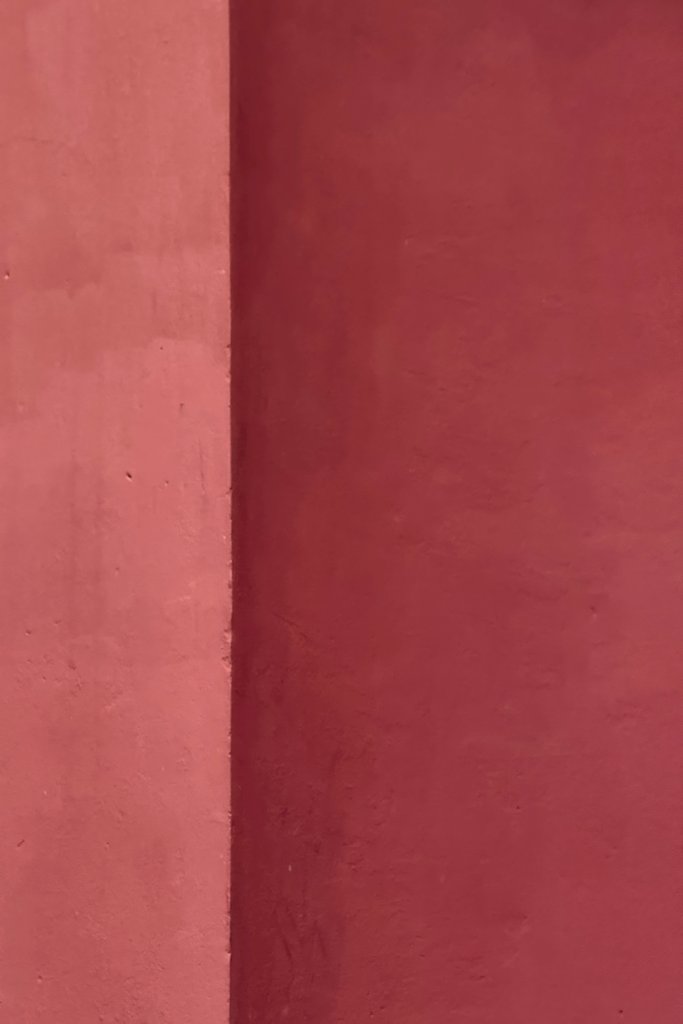 Yevhenii Deshko - Minimalistic image of a vibrant red wall showcasing geometric patterns and textures.
