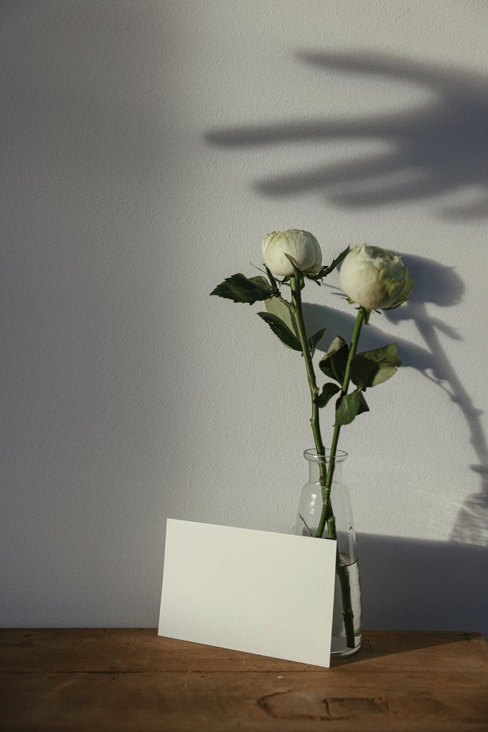 Cup of  Couple - A minimalist mockup featuring white roses in a vase with a blank card on a wooden table; perfect for invitations or messages.