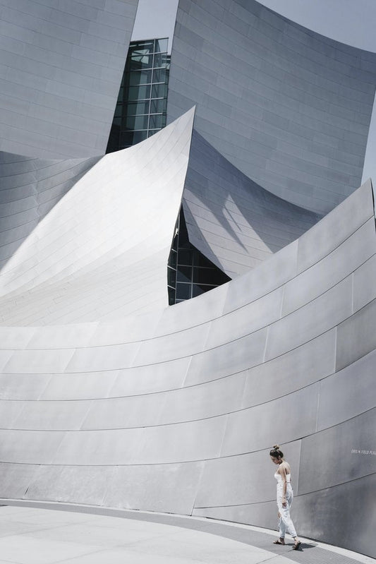 Brady Knoll - Sleek metallic architectural structure with a lone woman walking.