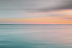 Jess Loiterton - Tranquil ocean view during sunset with soft pastel colors over the horizon.
