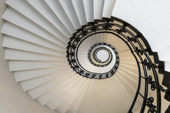 Wolfgang Weiser - Stunning upward view of a spiral staircase in Hamburg, showcasing modern architectural elegance.