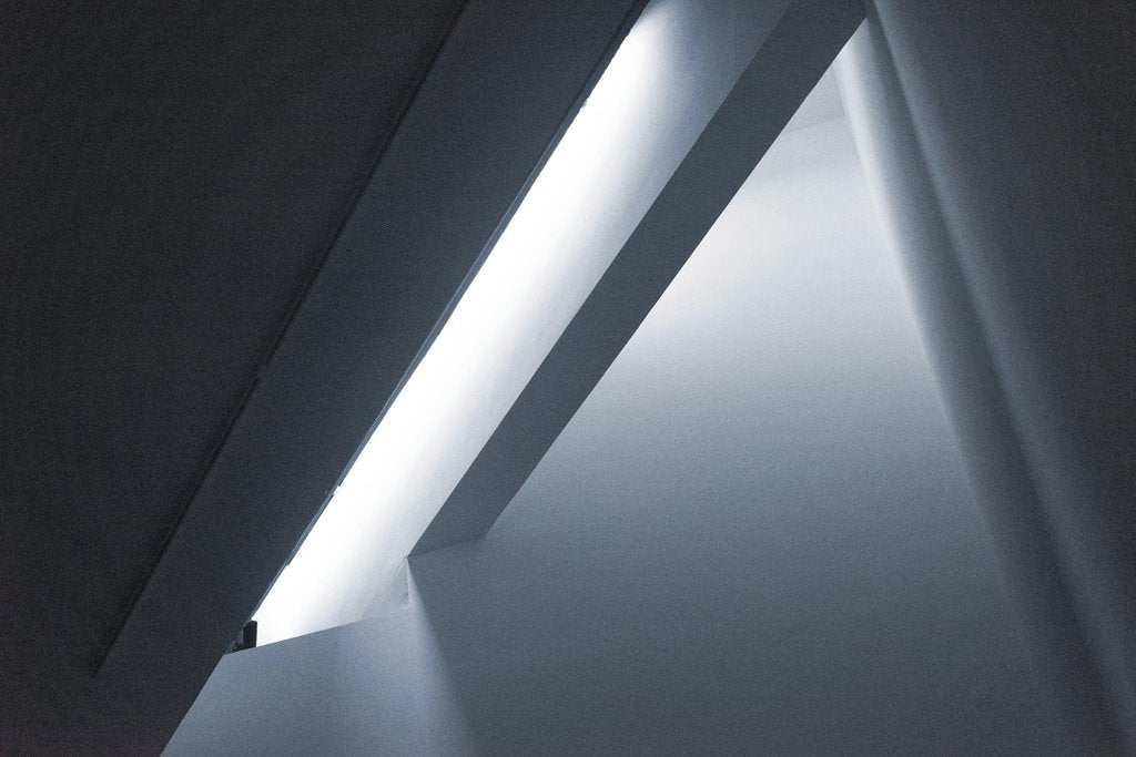 David Yu - Minimalist interior with contemporary illuminated ceiling design featuring geometric shapes.