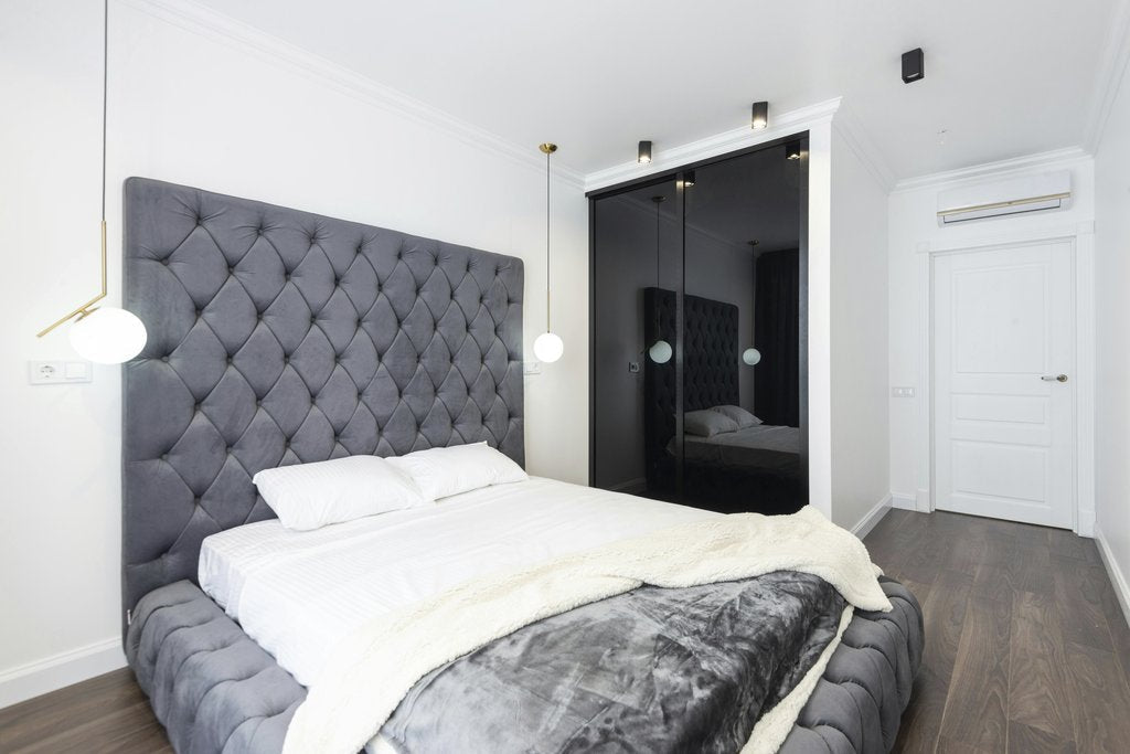 Max Vakhtbovycn - A sleek bedroom design featuring a gray upholstered bed and elegant lighting, perfect for modern interiors.