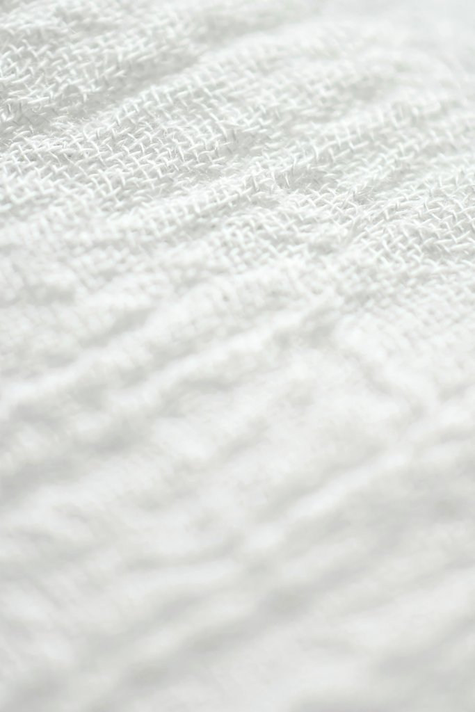 Eva Bronzini - Macro shot of textured white fabric with a soft and clean appearance.