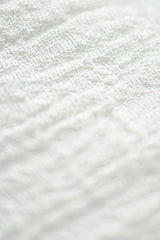 Eva Bronzini - Macro shot of textured white fabric with a soft and clean appearance.