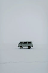 Julia Volk - A solitary van traverses a vast snowy expanse in Russia, capturing winter's stark beauty.