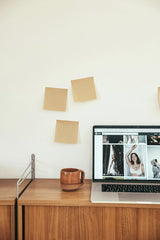 Cup of  Couple - A minimalist workspace features a laptop, sticky notes, and a wooden desk, ideal for remote work inspiration.
