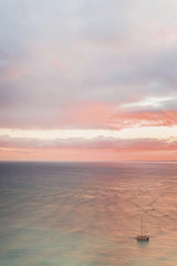 Jess Loiterton - Tranquil ocean view at sunset with a lone boat beneath a pink sky.