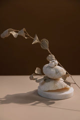 cottonbro studio - Artistic arrangement of stones and dry branch against a warm background, creating a minimalist composition.