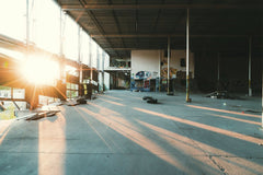 Nick Bee - An abandoned warehouse interior with graffiti art and glowing sunlight streaming in.
