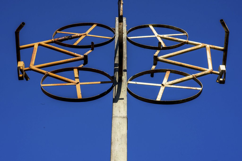 Victor  Moragriega - Metal sculpture resembling bicycles against a bright blue sky, capturing creativity and artistry.