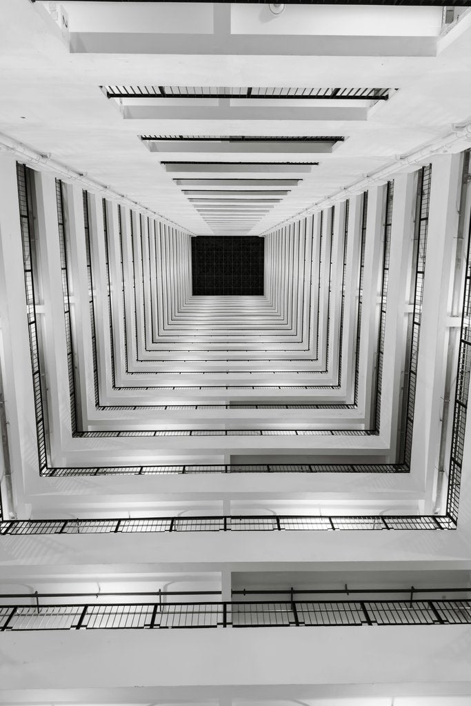 Neevin Alvin ✳️ - Dramatic black and white view of a modern vertical staircase from below.