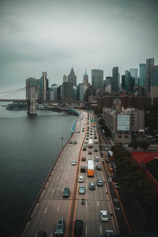 Etkin Celep - Dynamic aerial view showcasing Manhattan skyline and bustling traffic on the bridge.