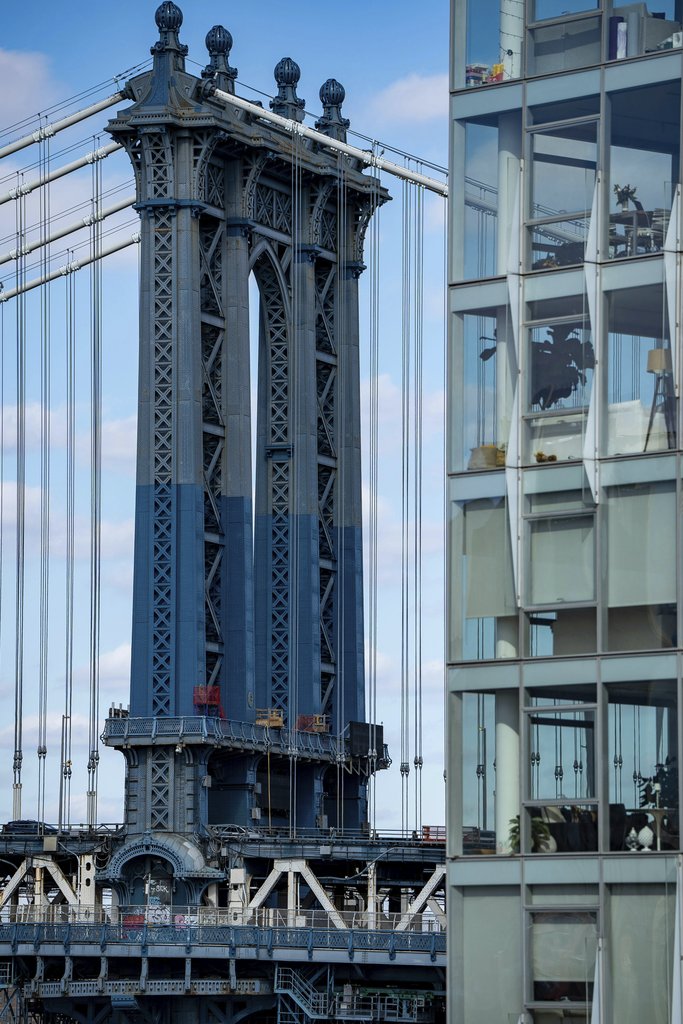 Fatih Turan - A striking view of the Manhattan Bridge alongside modern glass architecture in New York City.