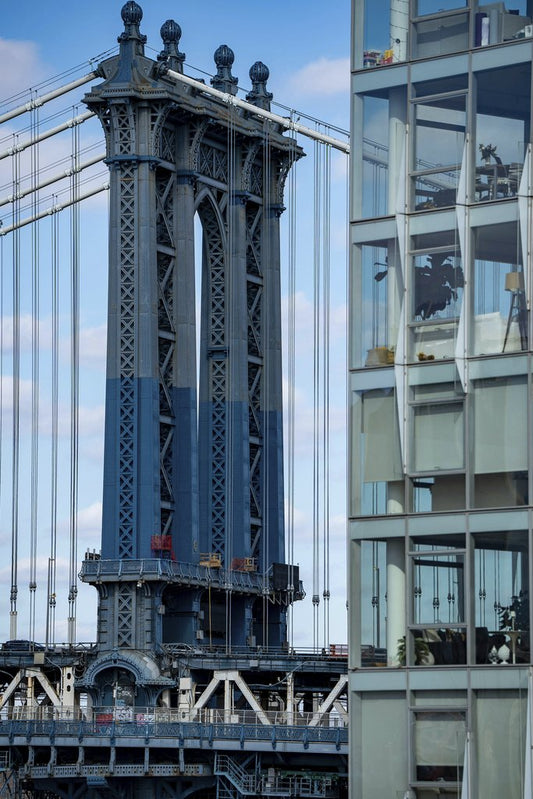 Fatih Turan - A striking view of the Manhattan Bridge alongside modern glass architecture in New York City.